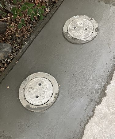 photo of two newly-set covers to sewer line