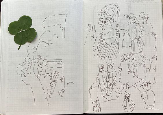 sketches of people at or around a cafe next to a four-leaf clover