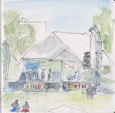 A line and wash sketch of an outdoors stage at an event with a couple of performers standing on it. Two signs in the front of the stage read WHOLE EARTH.