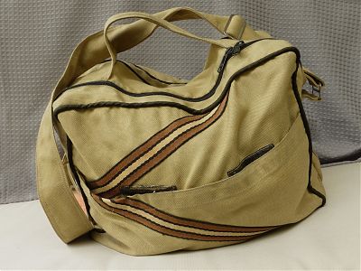 A photo of a beige yellow piece of soft luggage with diagonal brown and yellow stripes on it.
